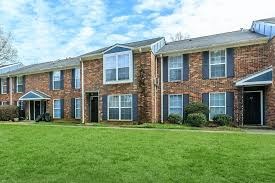 A brick apartment building with a green lawn in front.